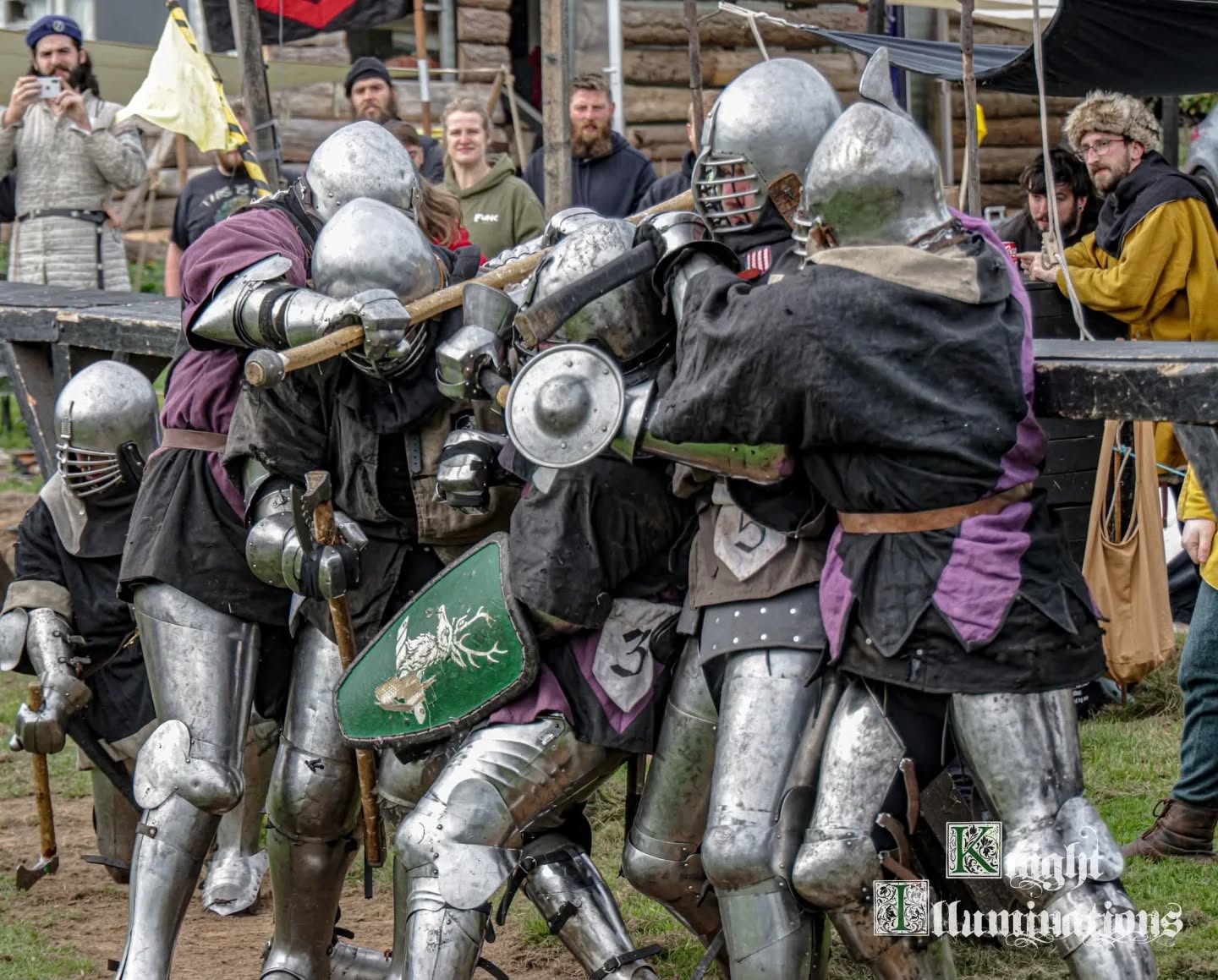 A group of armoured people wrestling with one in the centre